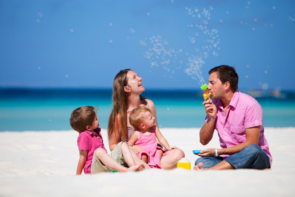 Family of four having fun on tropical beach